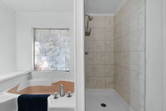 a bathroom with a tub shower and a sink