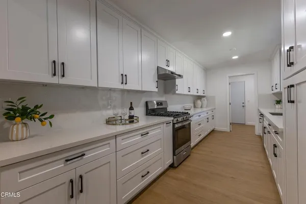 a large kitchen with stainless steel appliances granite countertop a sink and cabinets