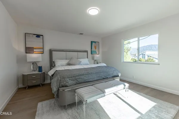 a bedroom with a bed and a potted plant