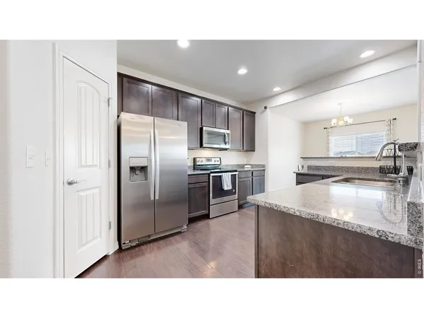 a kitchen with a refrigerator sink and a stove top oven