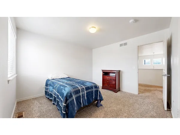 a living room with a bed and dresser
