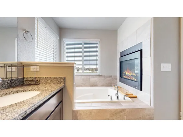 a bathroom with a granite countertop sink mirror and bathtub