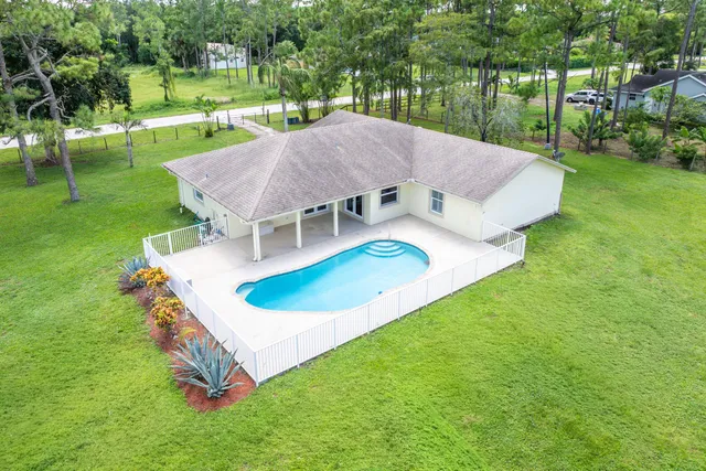 a aerial view of a house with a yard table and chairs