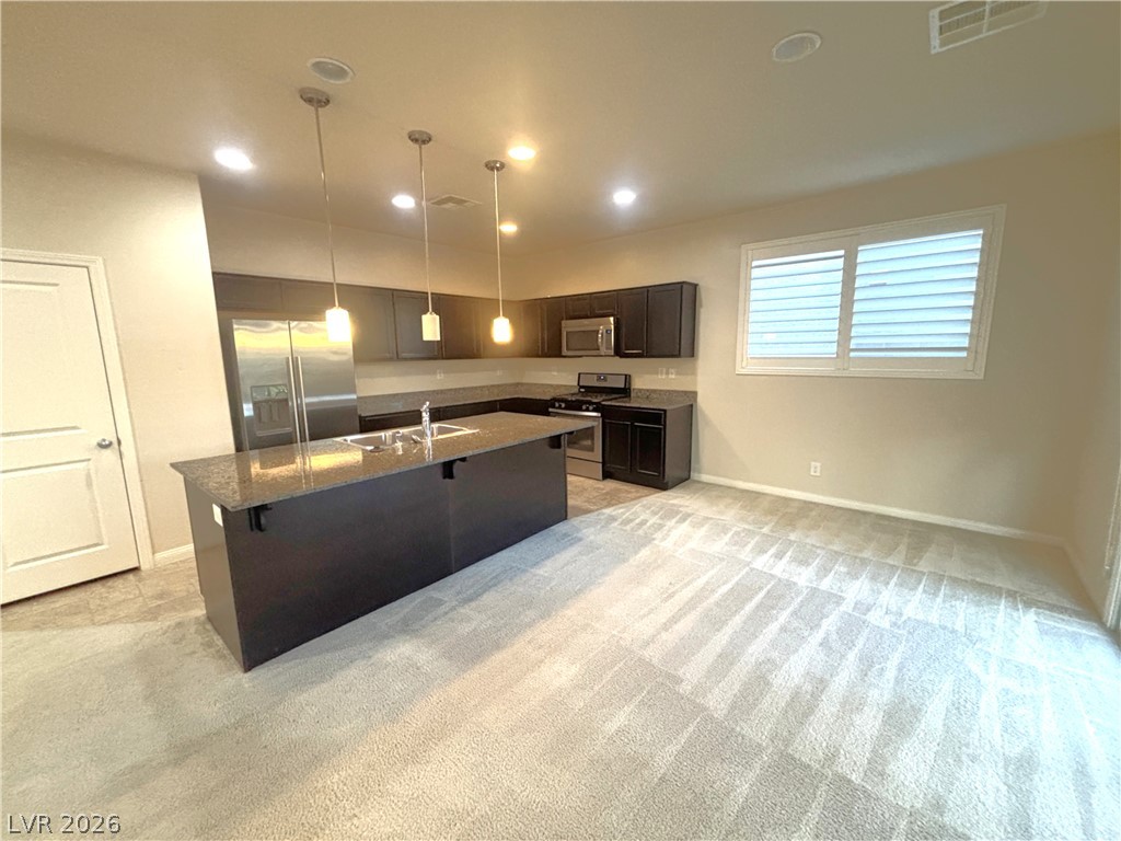 121 Elm Reed Avenue Las Vegas, NV 89113 - Photo 10 of 30 A well-appointed kitchen island anchors this open-concept living space, featuring contemporary finishes and abundant light.