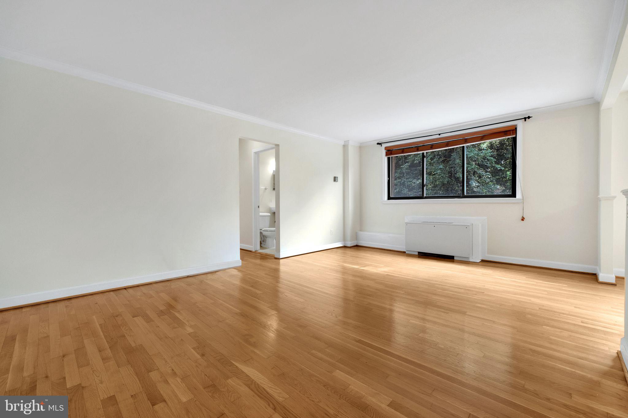 2725 39th Street Northwest, Unit 307 Washington, DC 20007 - Photo 3 of 18 a view of an empty room with wooden floor and a window