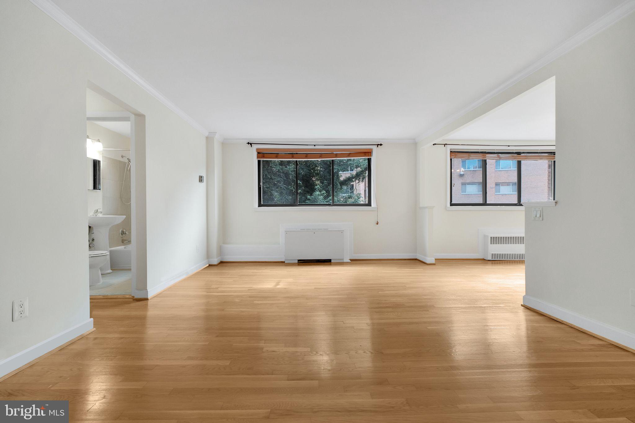 2725 39th Street Northwest, Unit 307 Washington, DC 20007 - Photo 5 of 18 a view of an empty room with wooden floor and a window