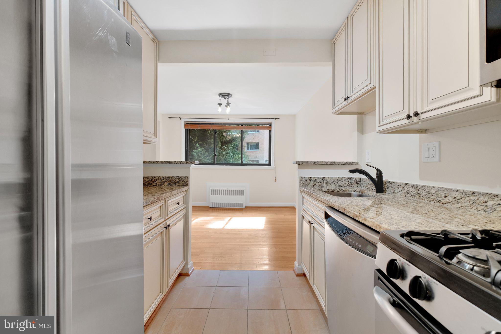 2725 39th Street Northwest, Unit 307 Washington, DC 20007 - Photo 10 of 18 a kitchen with stainless steel appliances granite countertop a stove and a sink