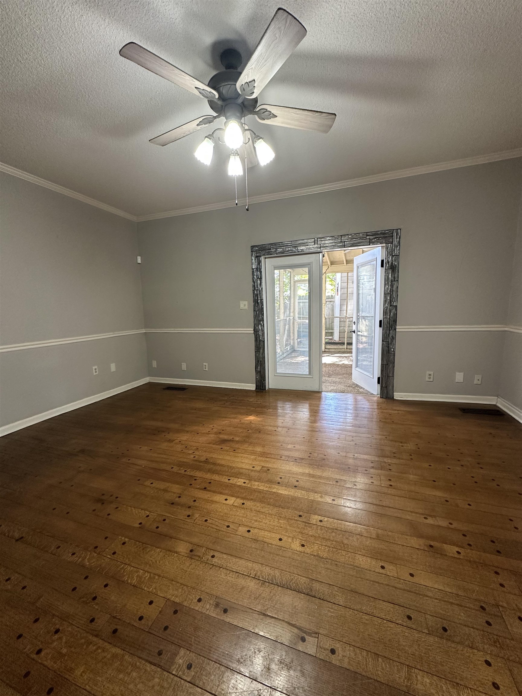 6939 Amberly Road, Unit 6939 Memphis, TN 38119 - Photo 4 of 14 Empty room featuring dark wood-style flooring, a textured ceiling, and crown molding