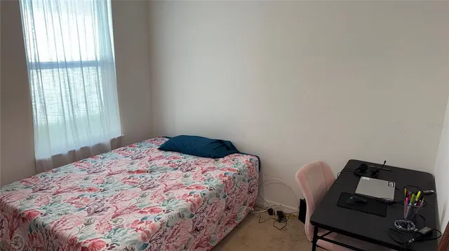 a bedroom with a bed a chair and a window