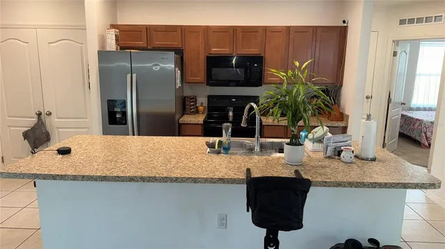 a kitchen with stainless steel appliances granite countertop a sink and a refrigerator