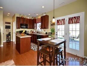 306 Lumber River Road Fletcher, NC 28732 - Photo 2 of 15 a room with stainless steel appliances kitchen island granite countertop a table chairs and a refrigerator
