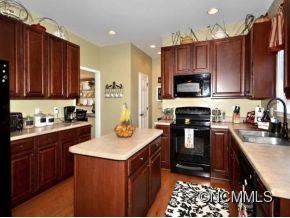 306 Lumber River Road Fletcher, NC 28732 - Photo 3 of 15 a kitchen with kitchen island granite countertop a stove top oven microwave and cabinets