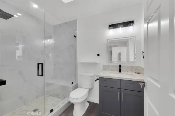 a bathroom with a sink a toilet and shower