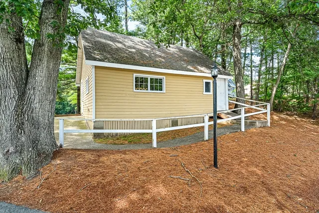 a view of backyard with wooden fence and large trees
