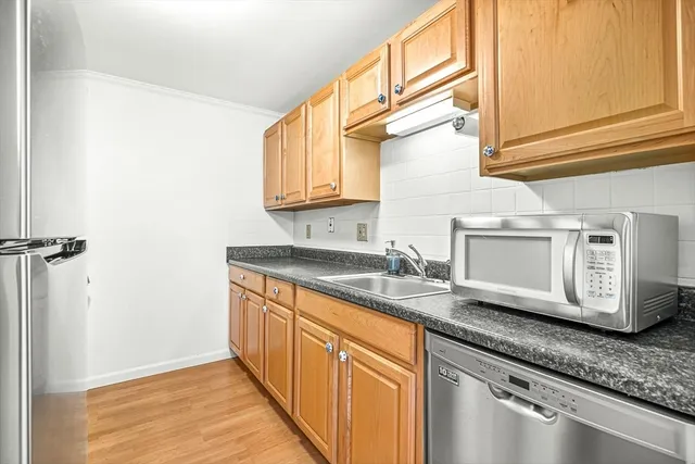 a kitchen with granite countertop stainless steel appliances a sink and cabinets