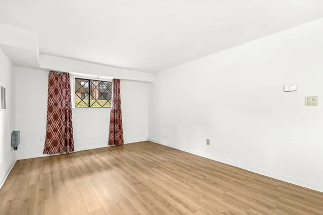 a view of empty room with wooden floor