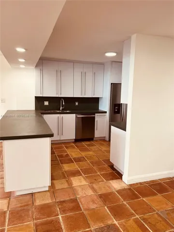a kitchen with stainless steel appliances a refrigerator sink and microwave