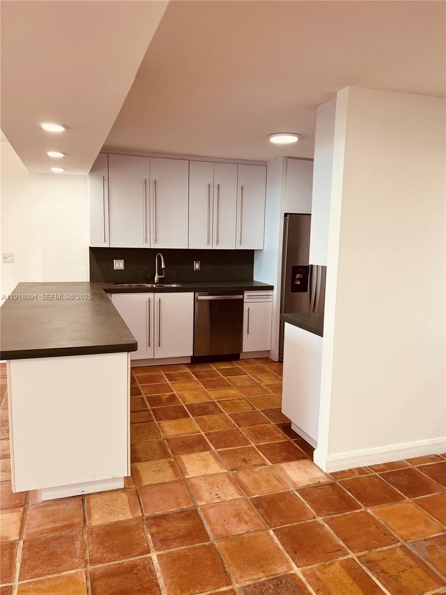 1 Grove Isle Drive, Unit A405 Miami, FL 33133 - Photo 12 of 21 a kitchen with stainless steel appliances a refrigerator sink and microwave