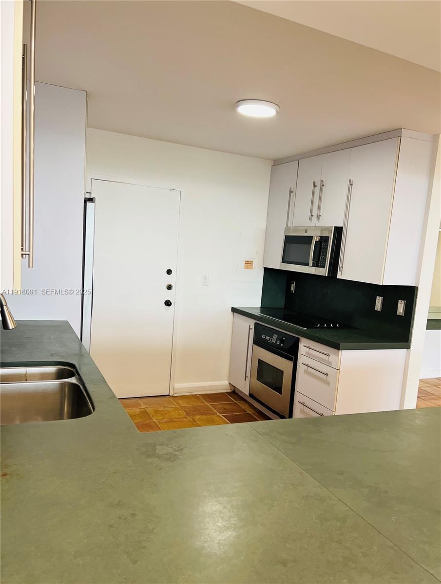 1 Grove Isle Drive, Unit A405 Miami, FL 33133 - Photo 13 of 21 a kitchen with kitchen island a stove a sink and a refrigerator