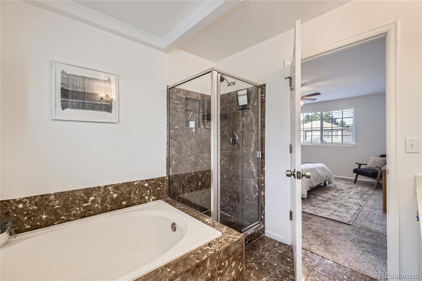 1552 Spring Water Place Highlands Ranch, CO 80129 - Photo 14 of 28 a bathroom with a tub a toilet and a shower