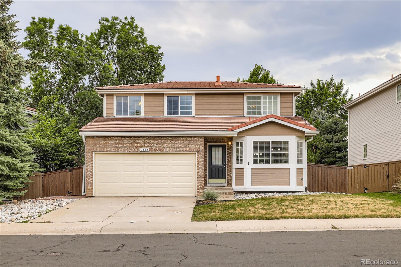 1552 Spring Water Place Highlands Ranch, CO 80129 - Photo 28 of 28 a front view of a house with a yard and garage