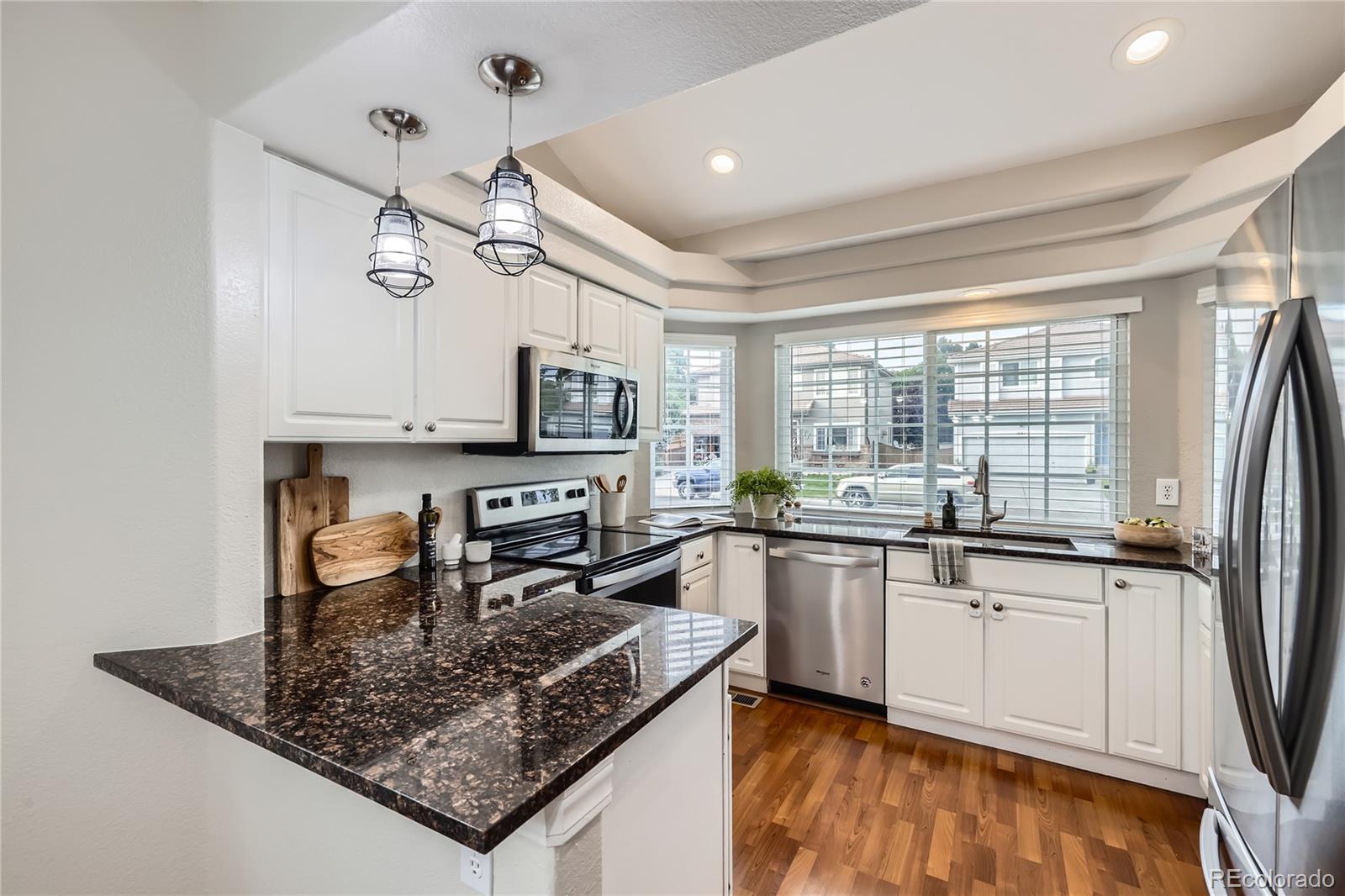 1552 Spring Water Place Highlands Ranch, CO 80129 - Photo 6 of 28 a kitchen with stainless steel appliances granite countertop a sink stove and refrigerator