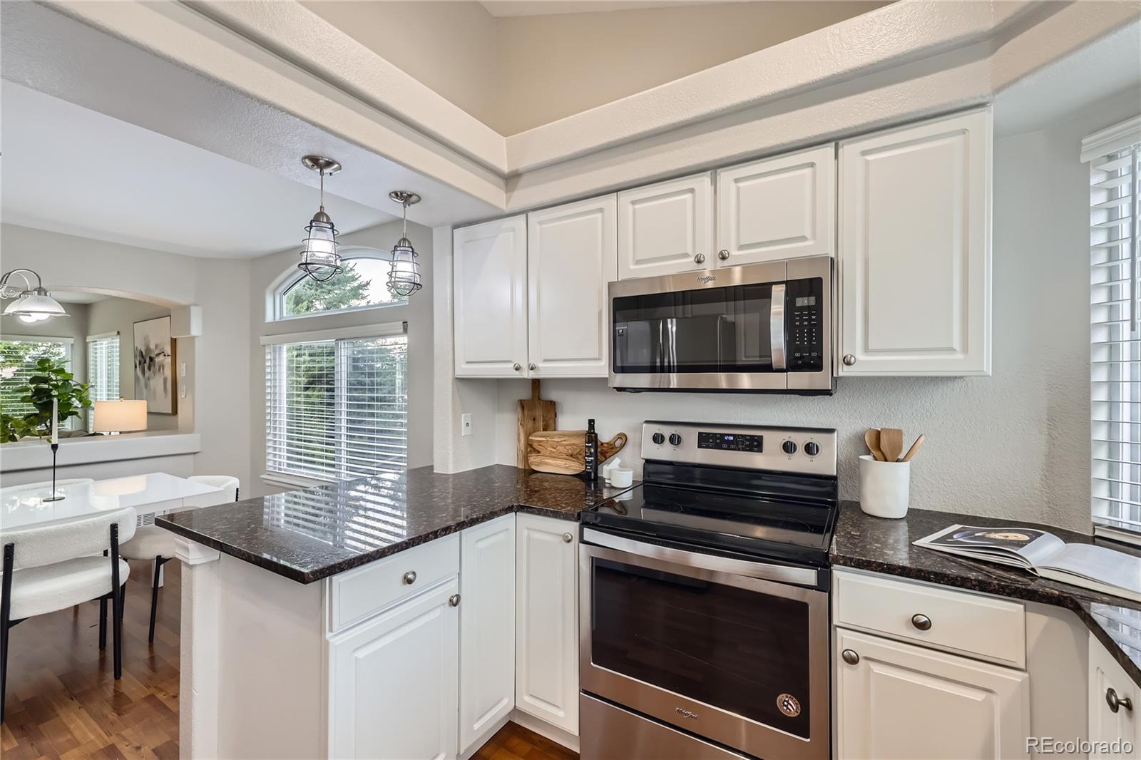 1552 Spring Water Place Highlands Ranch, CO 80129 - Photo 7 of 28 a kitchen with granite countertop a sink stove and microwave
