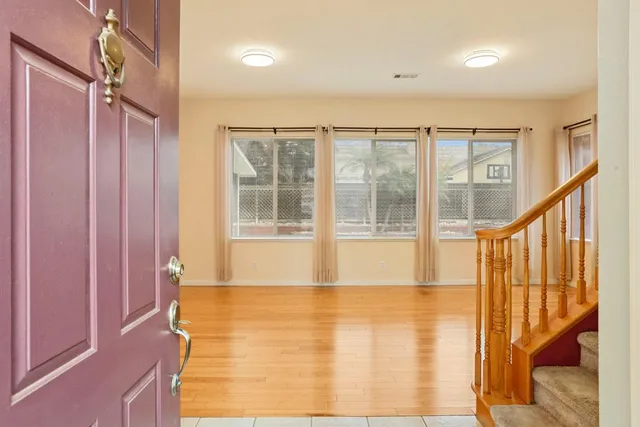 a view of an empty room with a fireplace and a window
