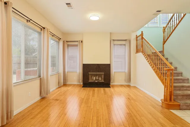a view of a hallway with wooden floor and staircase