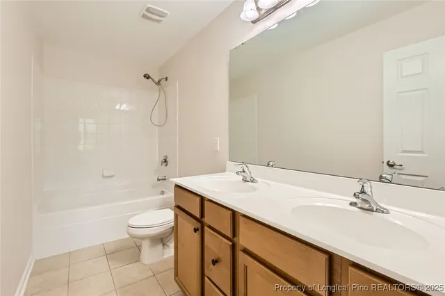 a bathroom with a double vanity sink toilet mirror and shower