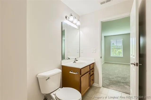a bathroom with a toilet sink vanity and mirror