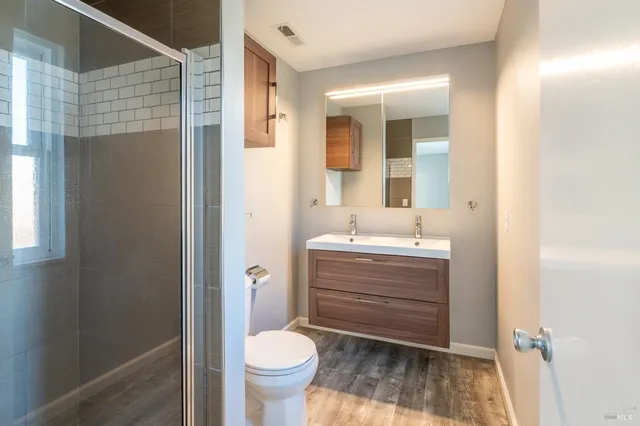 a bathroom with a sink toilet a mirror and shower