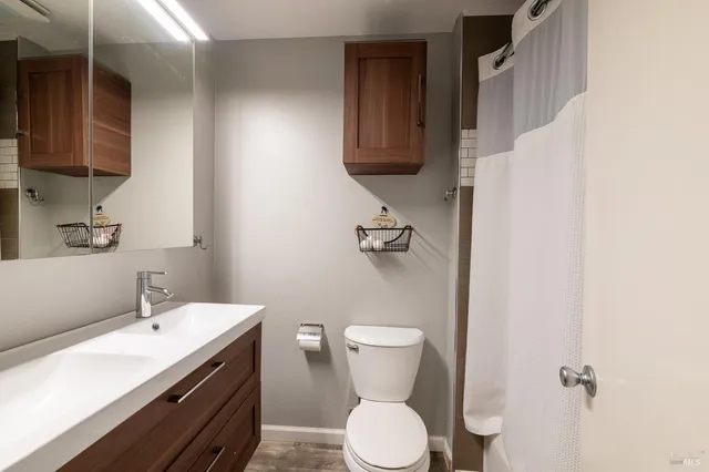 a bathroom with a sink a toilet and mirror
