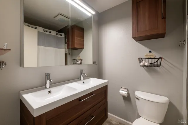 a bathroom with a sink mirror and toilet