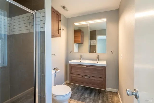 a bathroom with a toilet a sink and mirror