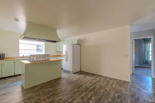 a view of a kitchen with wooden floor and electronic appliances