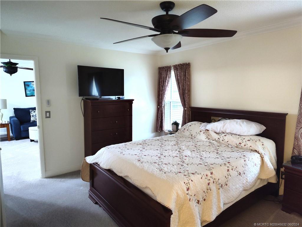 Undisclosed Address Stuart, FL 34997 - Photo 23 of 64 a spacious bedroom with a bed and a flat screen tv