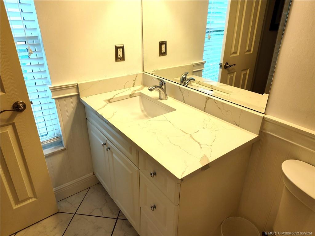 Undisclosed Address Stuart, FL 34997 - Photo 30 of 64 a bathroom with a granite countertop sink and a mirror