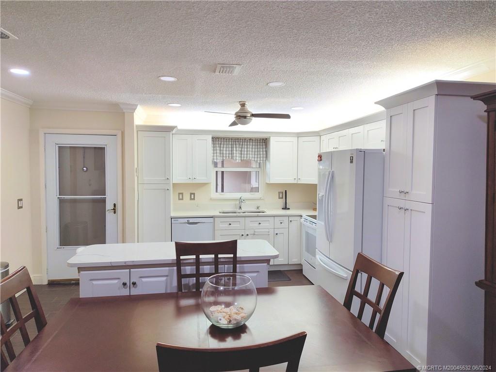 Undisclosed Address Stuart, FL 34997 - Photo 4 of 64 a kitchen with a dining table chairs and refrigerator