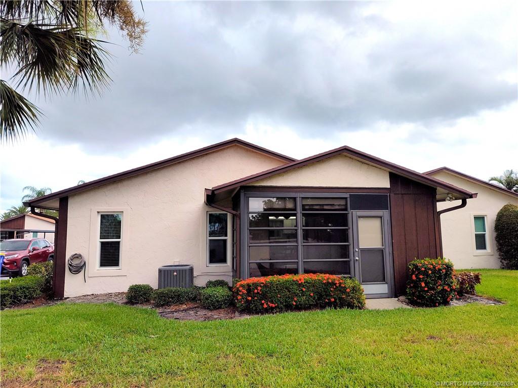 Undisclosed Address Stuart, FL 34997 - Photo 51 of 64 a front view of a house with a yard and garage