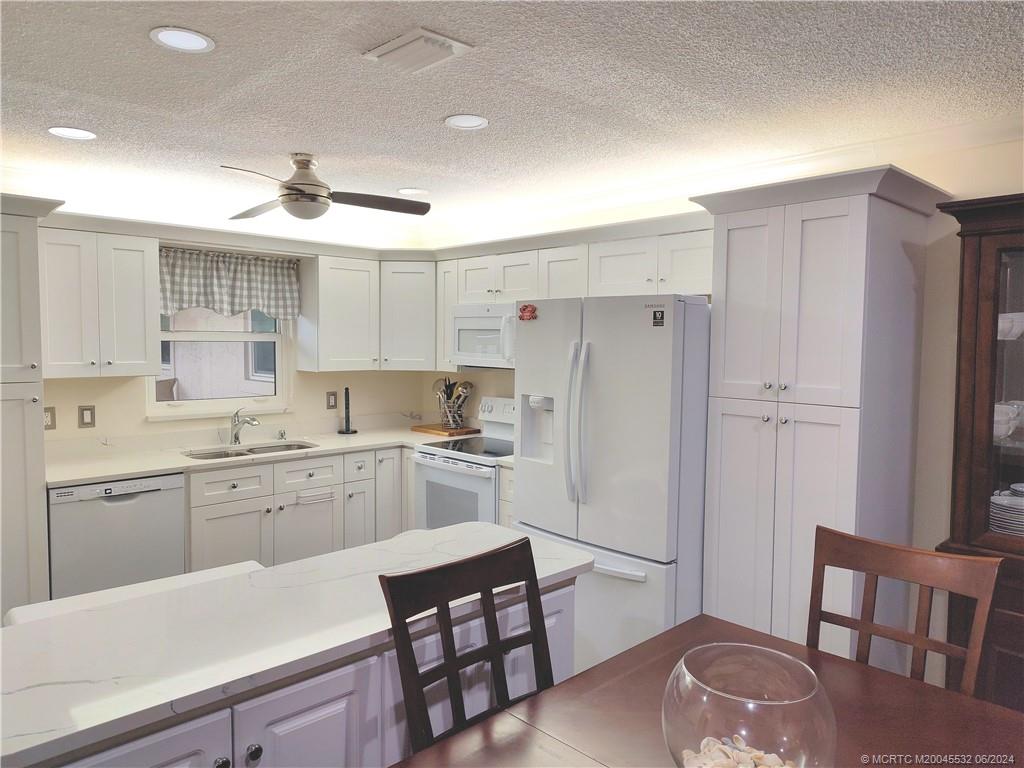Undisclosed Address Stuart, FL 34997 - Photo 7 of 64 a kitchen with white cabinets and stainless steel appliances