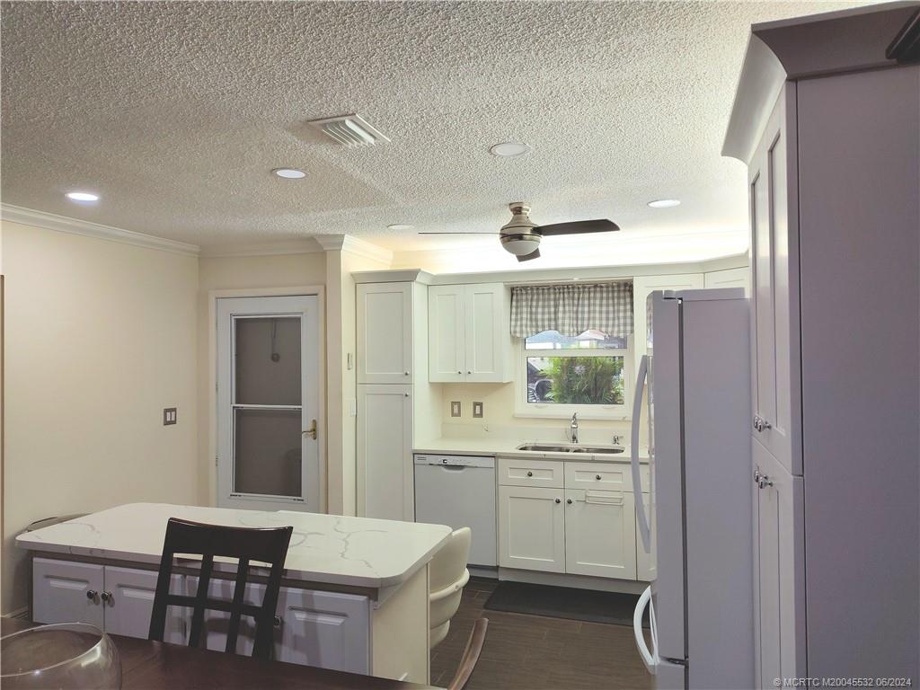 Undisclosed Address Stuart, FL 34997 - Photo 9 of 64 a kitchen with a sink dishwasher a dining table and chairs with wooden floor