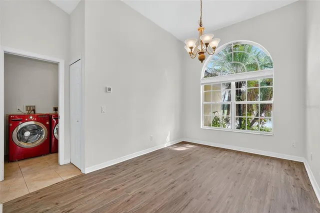 a view of a room with wooden floor chandelier and windows