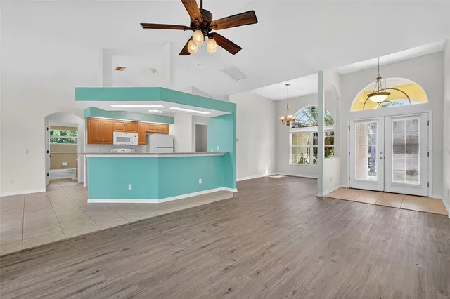 a view of a room with wooden floor and a ceiling fan