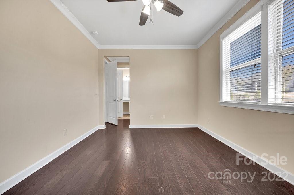 1271 Independence Street Tega Cay, SC 29708 - Photo 14 of 23 an empty room with wooden floor chandelier fan and windows