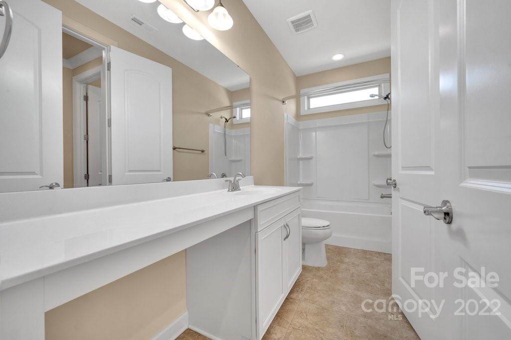 1271 Independence Street Tega Cay, SC 29708 - Photo 16 of 23 a bathroom with a granite countertop sink a toilet and shower