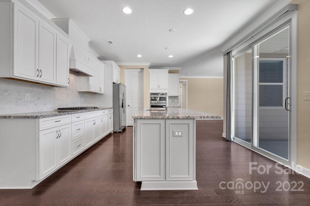 1271 Independence Street Tega Cay, SC 29708 - Photo 8 of 23 a kitchen with granite countertop white cabinets and stainless steel appliances
