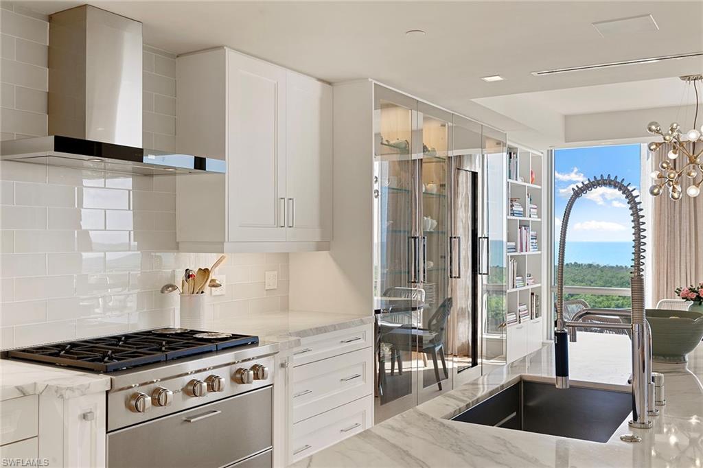 6897 Grenadier Boulevard, Unit 902 Naples, FL 34108 - Photo 12 of 50 a kitchen with granite countertop a stove a sink and a refrigerator