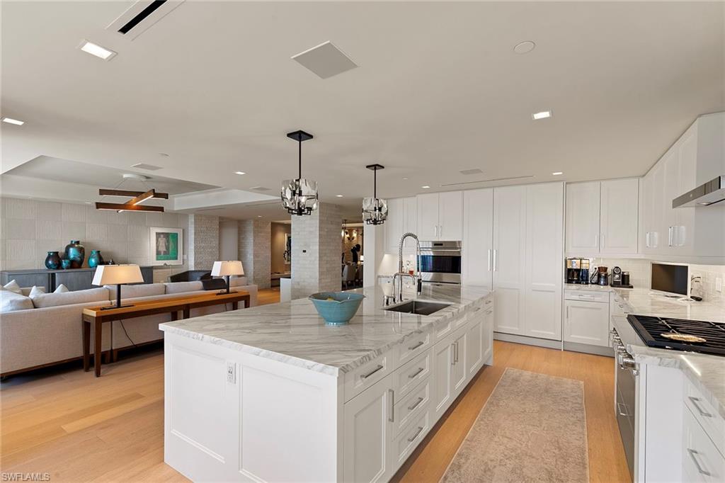 6897 Grenadier Boulevard, Unit 902 Naples, FL 34108 - Photo 15 of 50 a large white kitchen with lots of counter space and stainless steel appliances