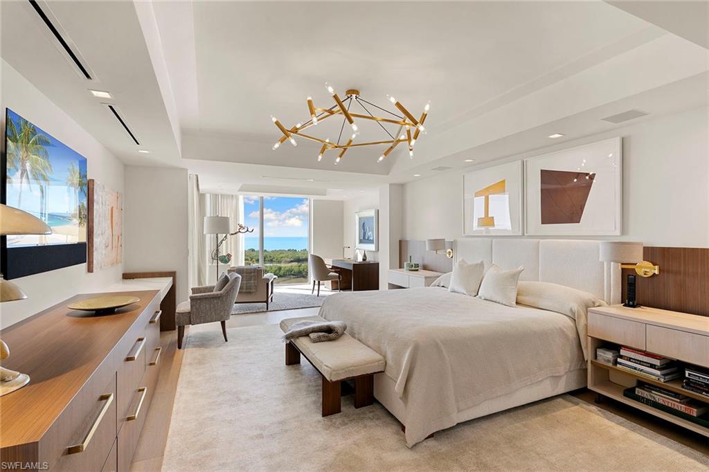 6897 Grenadier Boulevard, Unit 902 Naples, FL 34108 - Photo 22 of 50 a spacious bedroom with a bed a couch and a flat tv screen on the dresser